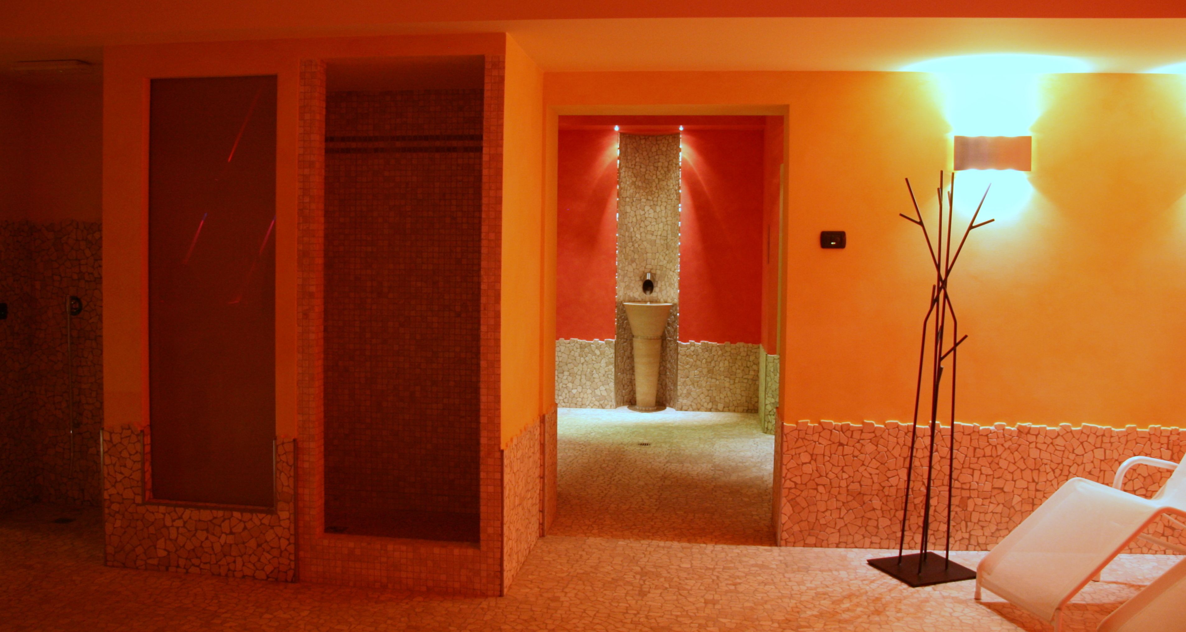 A hotel lobby with a reception area, a restroom, and a seating area with a floor lamp.