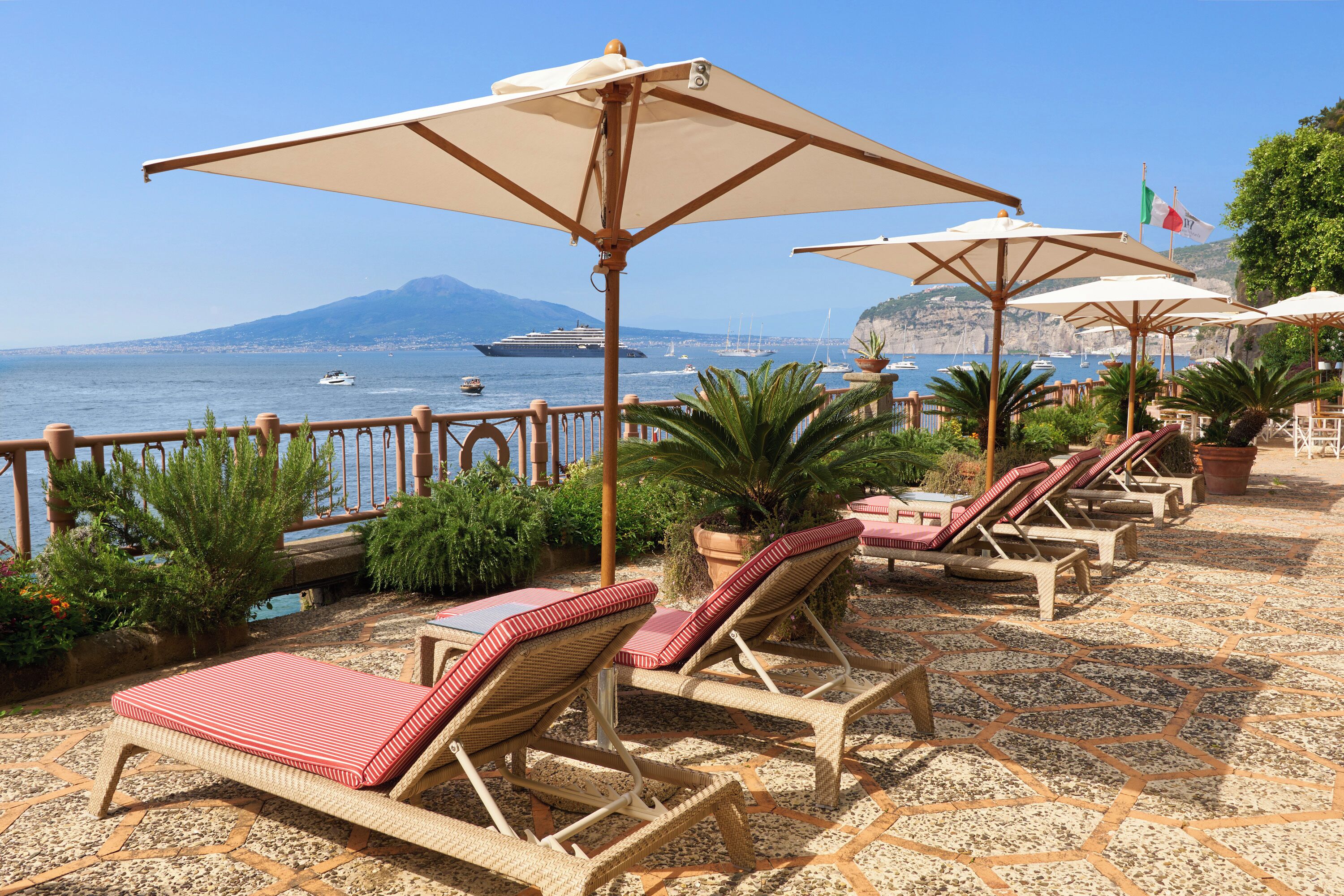 Privatstrand, schwarzer Sandstrand, Liegestühle, Sonnenschirme