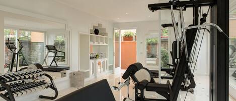 Un gimnasio moderno con equipo de ejercicio, una cinta de correr y un rack de pesas.