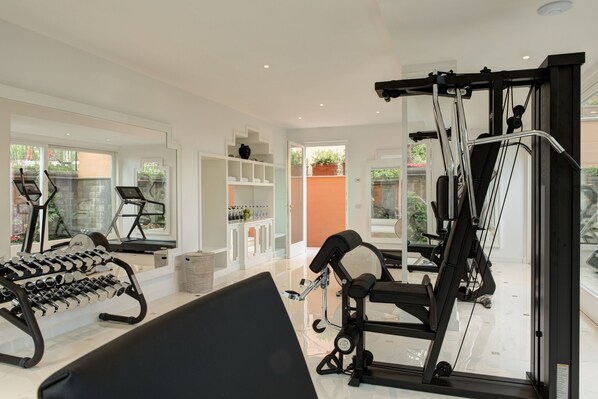 Un gimnasio moderno con equipo de ejercicio, una cinta de correr y un rack de pesas.