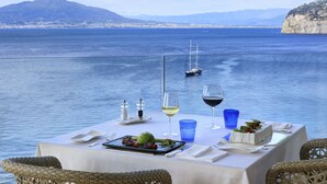 A table set for a meal with a view of the sea and mountains. - Grand Hotel Royal (Sorrento)