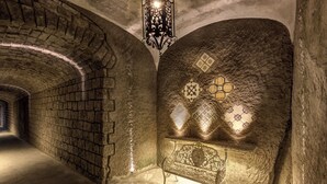A stone-walled corridor with a bench and a decorative lantern. - Grand Hotel Royal (Sorrento)