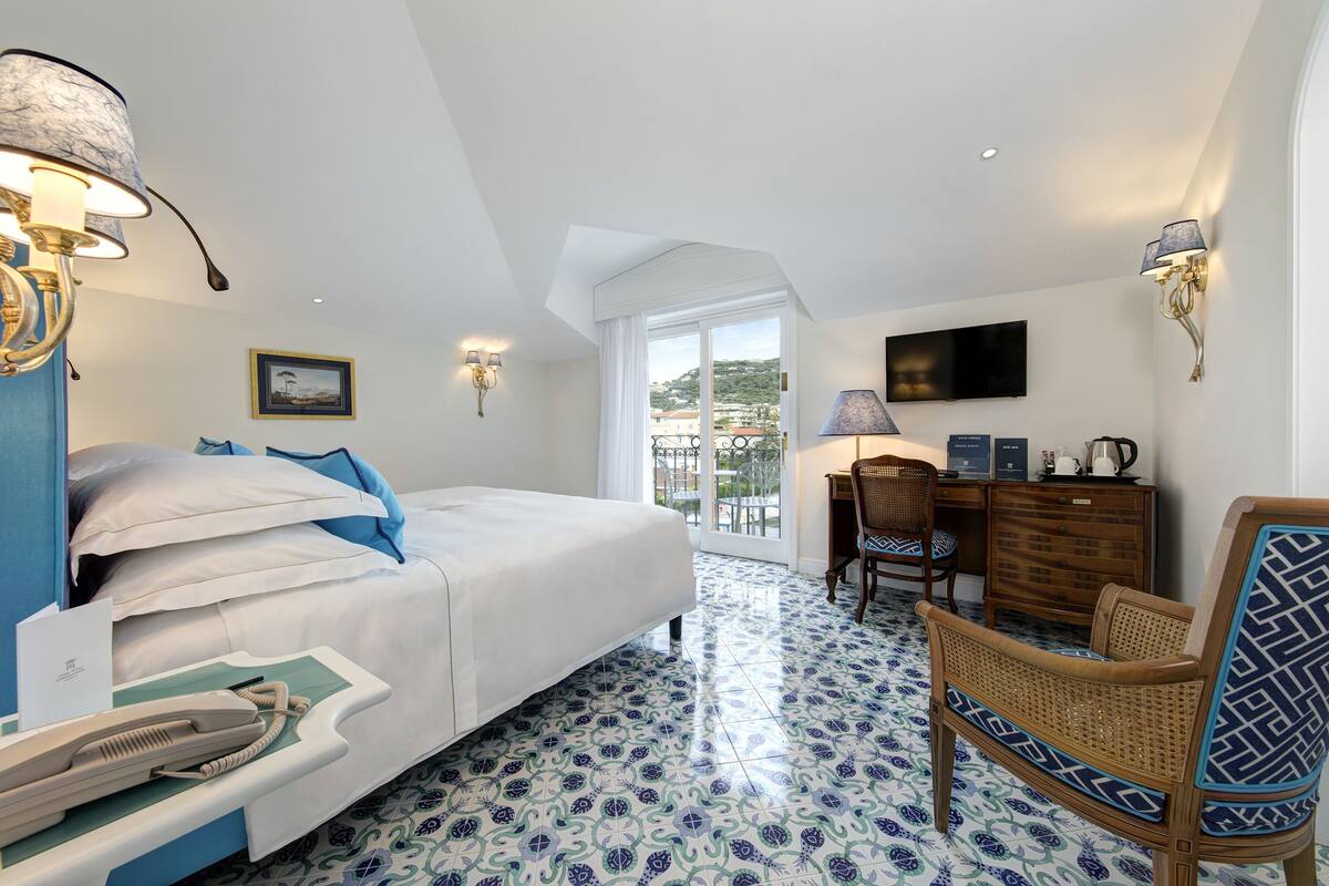 Een hotelkamer met een bed, een bureau, een stoel en uitzicht.