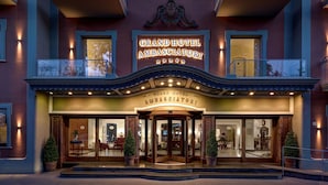 La façade du Grand Hôtel Ambassadori se distingue par son grand panneau lumineux, ses larges baies vitrées et son architecture classique.