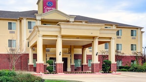 A Comfort Suites hotel with a two-story structure, a covered entrance, and a brick facade.