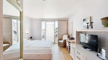 Une chambre d’hôtel avec un lit, une télévision, un bureau et une chaise.