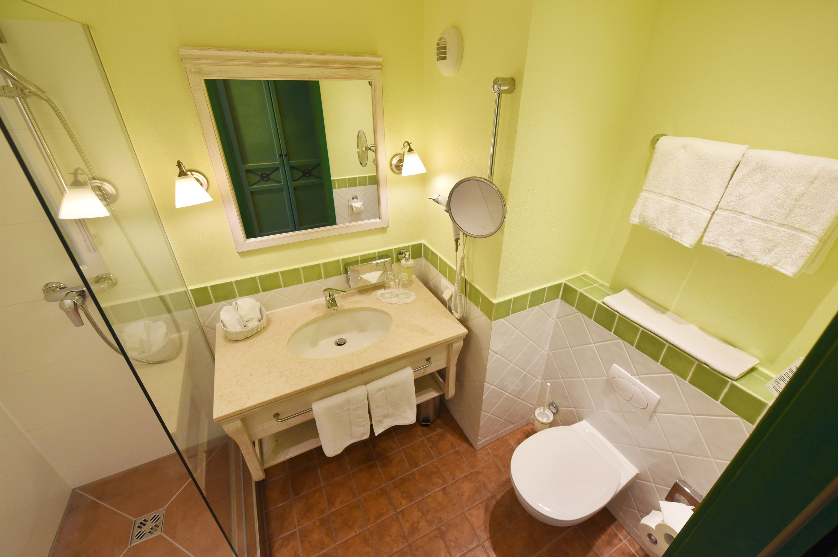 Ein Badezimmer mit Waschbecken, Spiegel, Toilette und Handtuchhalter.