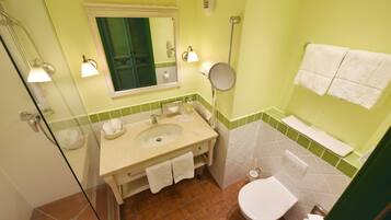 Ein Badezimmer mit Waschbecken, Spiegel, Toilette und Handtuchhalter.