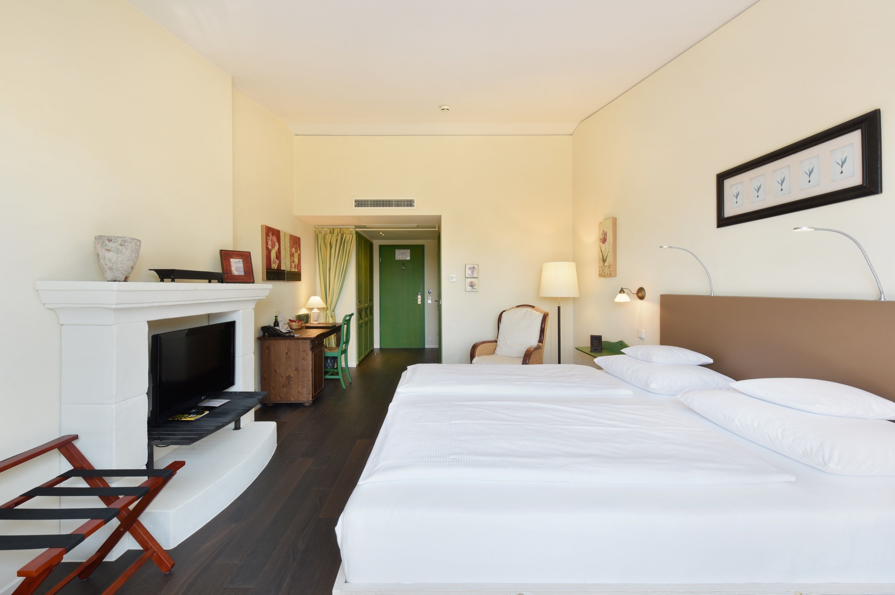 Une chambre d’hôtel équipée d’un lit, d’une cheminée, d’une télévision, d’un bureau et d’une chaise.