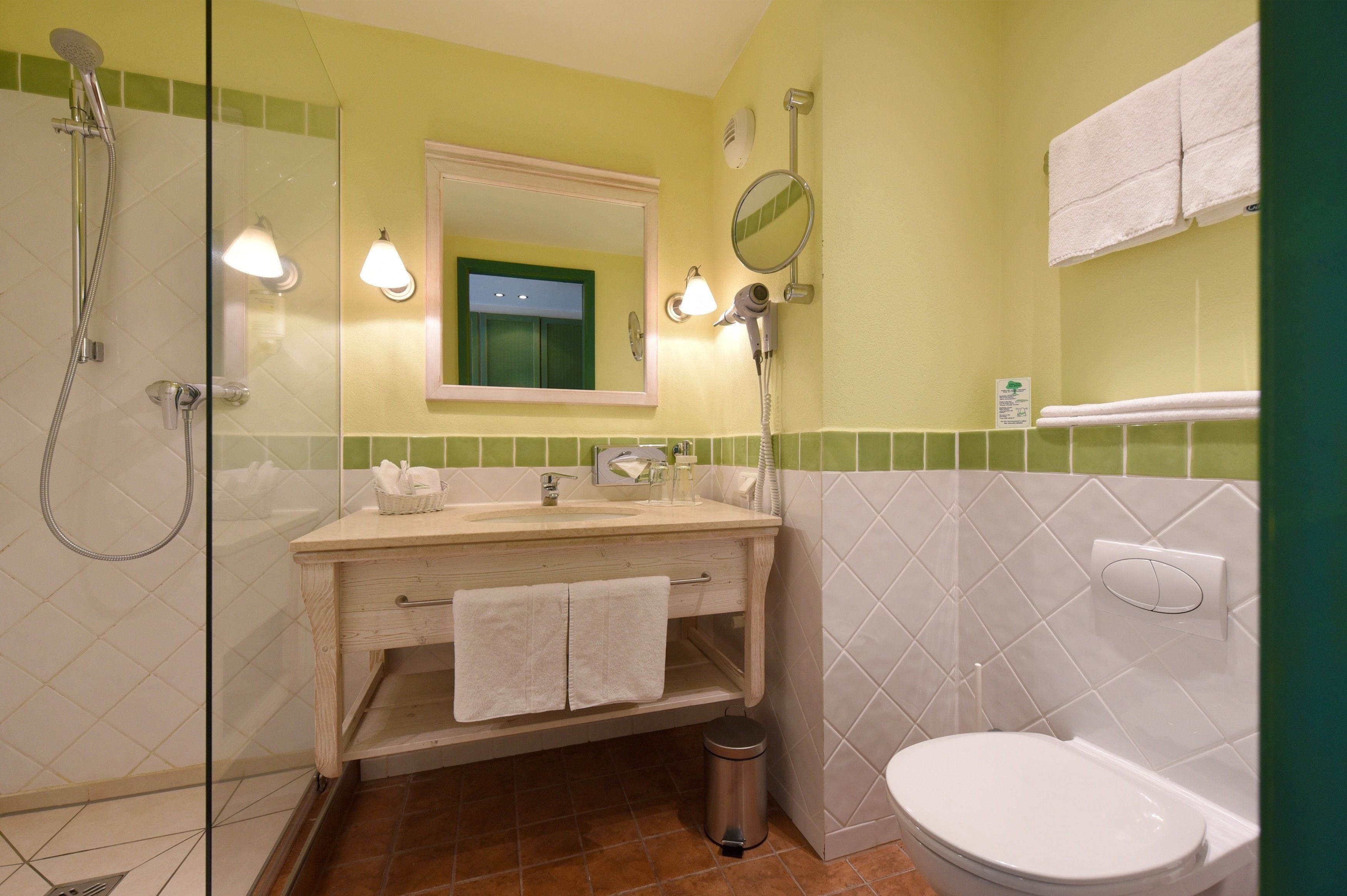 Ein Badezimmer mit Duschkabine, Waschbecken mit Spiegel und Toilette.