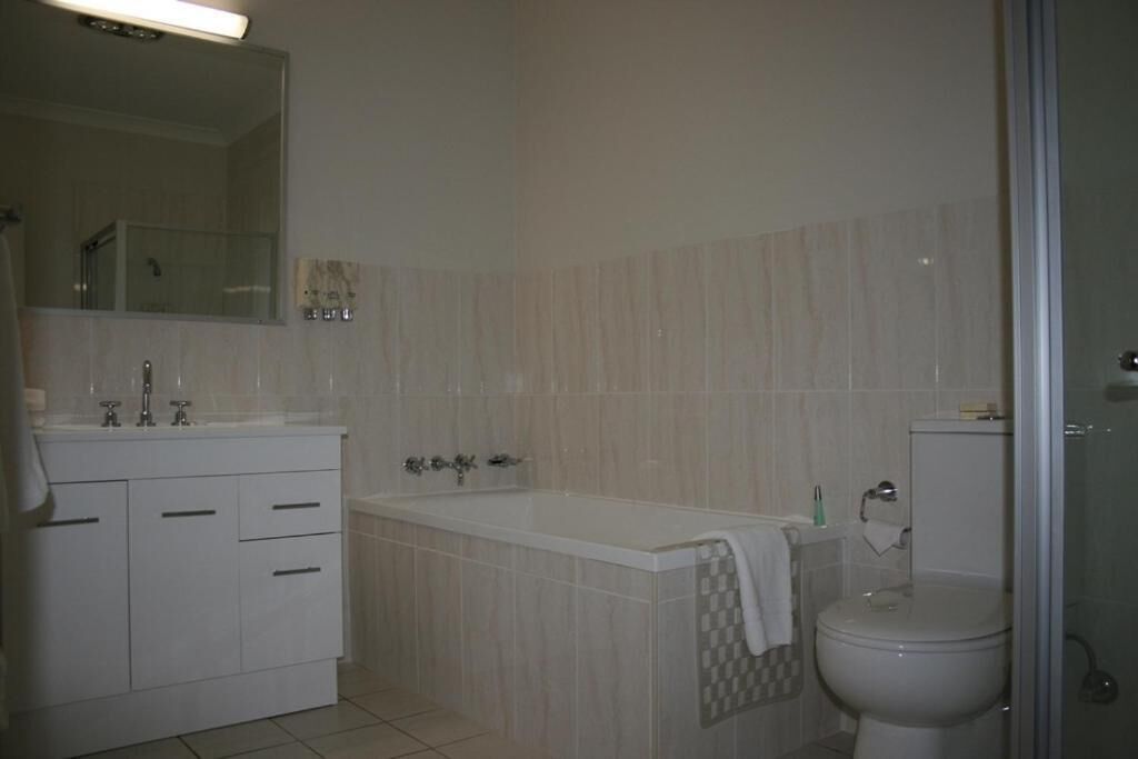 Een badkamer met een bad, toilet en wastafel.
