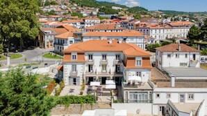 Un grand bâtiment doté d’une piscine, de nombreux balcons et d’une cour avec des espaces assise extérieurs.