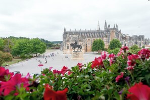 A historic building with a statue of a figure on horseback in front. - Hotel Lis Batalha (Batalha)