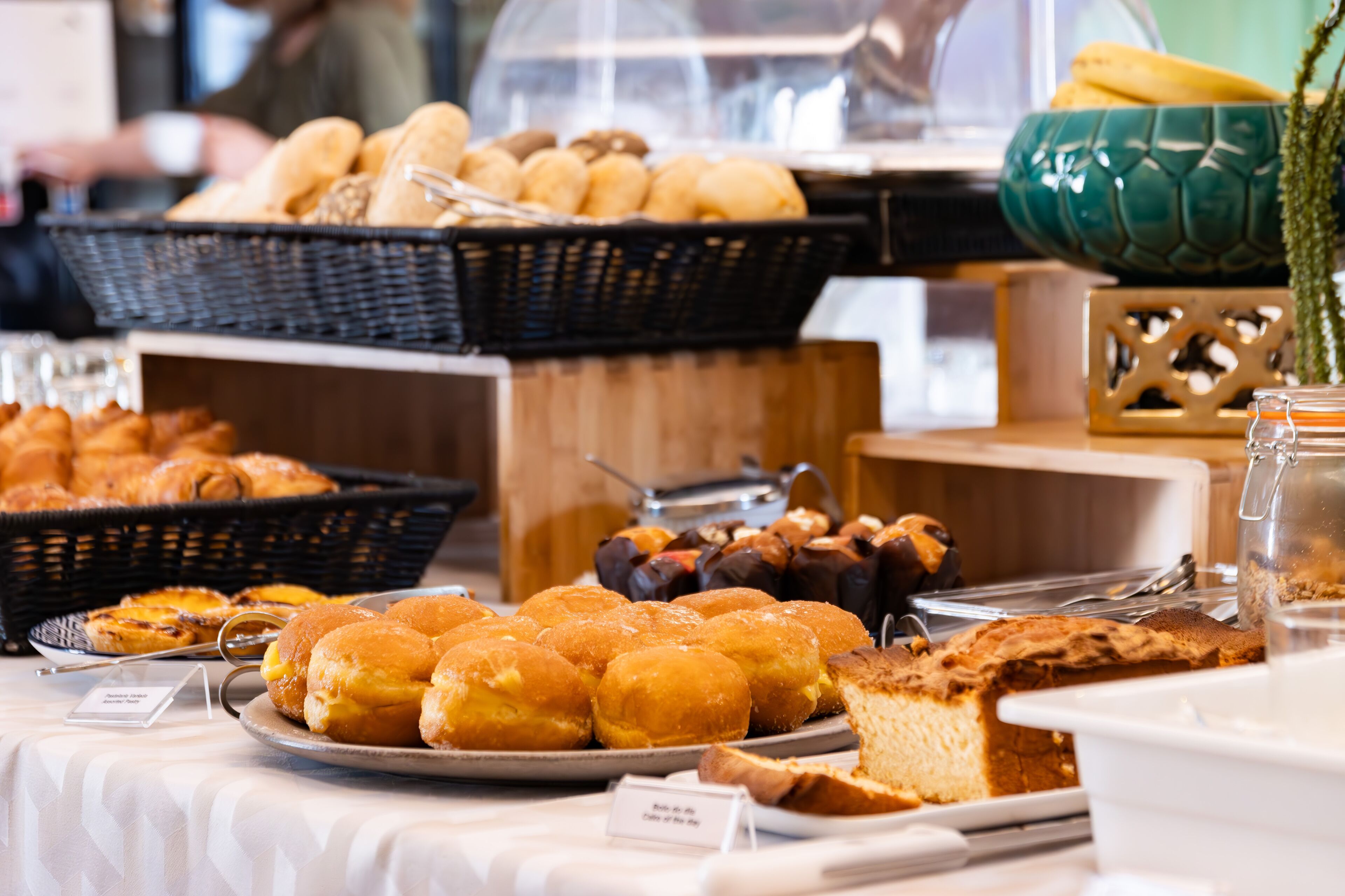 A buffet with various baked goods including bread, pastries, and a cake.