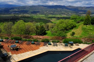 Una piscina al aire libre, sillones reclinables de piscina
