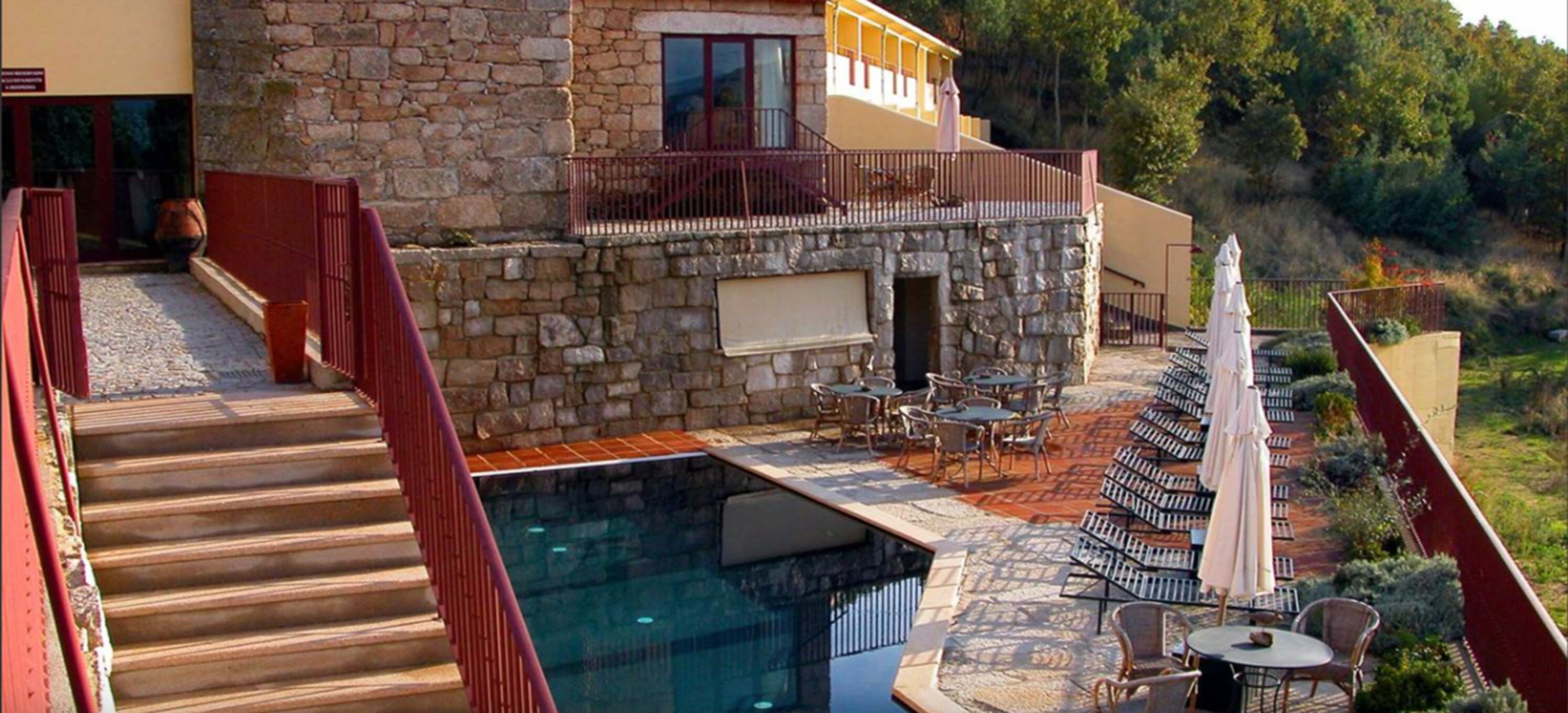 A stone building with a pool and outdoor seating area.