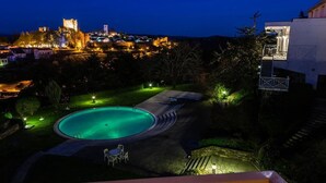 A nighttime view of a swimming pool with a castle in the background. - Pousada de Bragança - São Bartolomeu (Braganca)