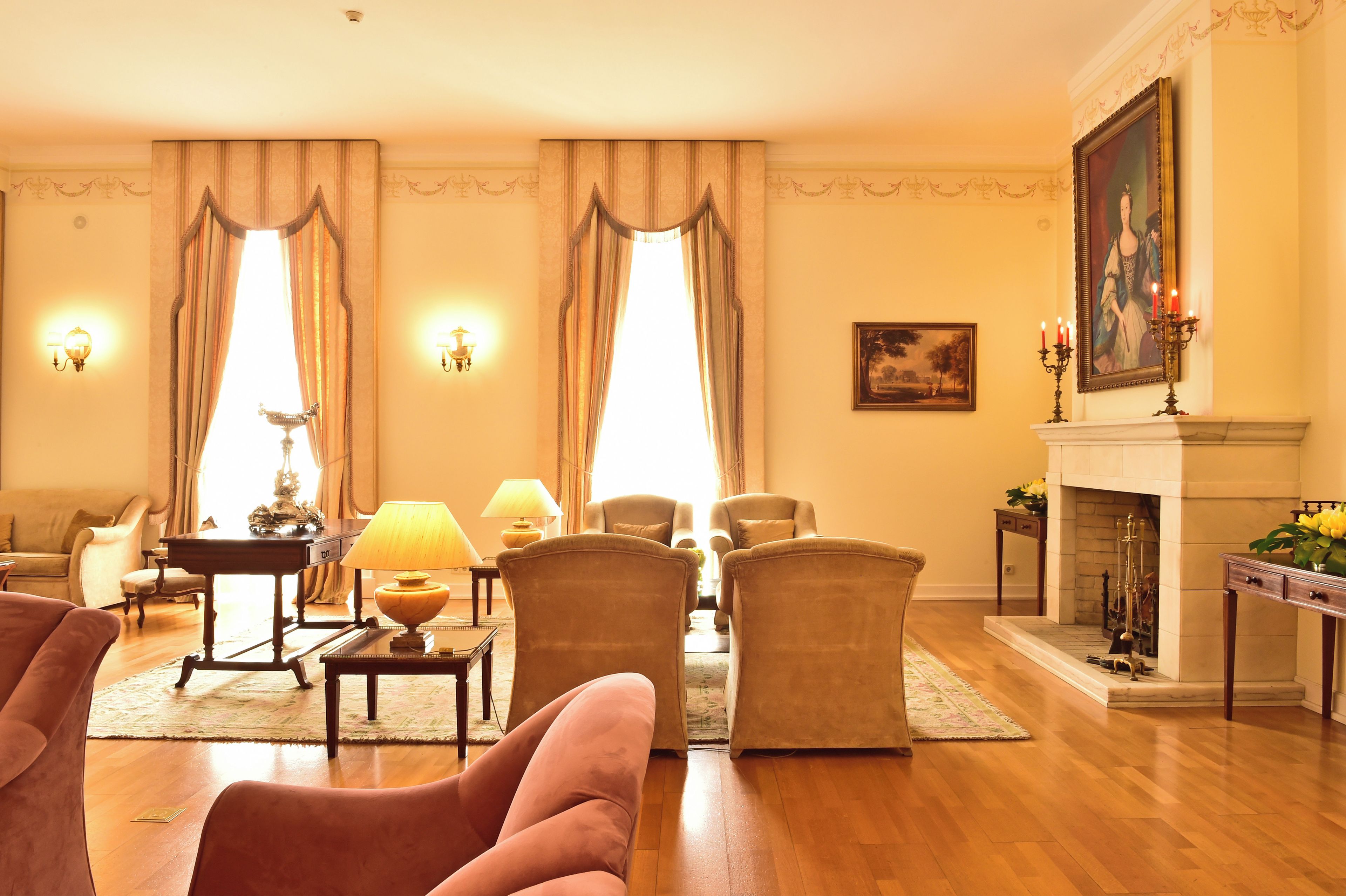 A well-lit living room with a fireplace, comfortable seating, and decorative wall sconces.