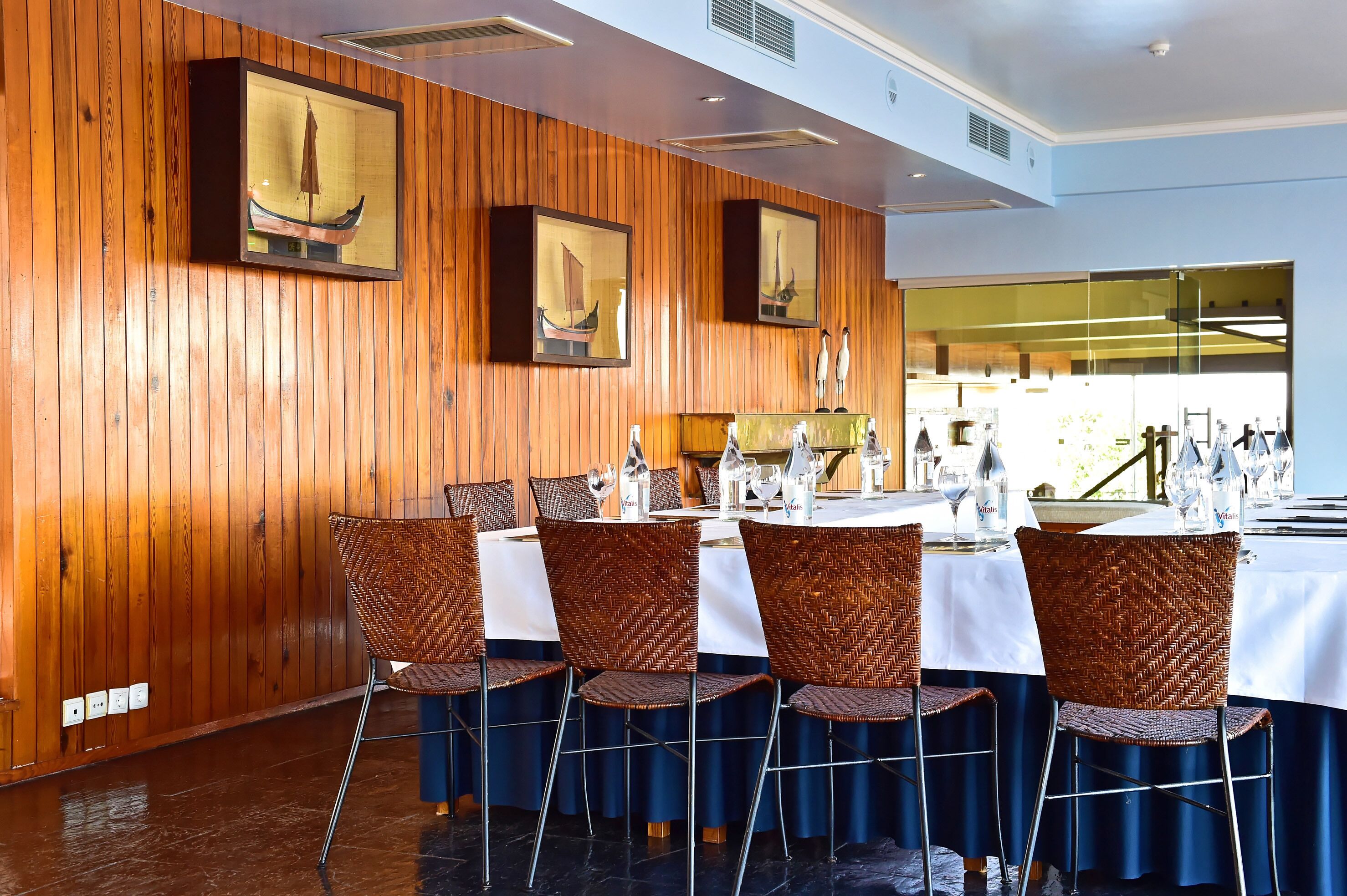 Ein Restaurant mit Holzwandverkleidung, gerahmten Kunstwerken und einem gedecktem Tisch.