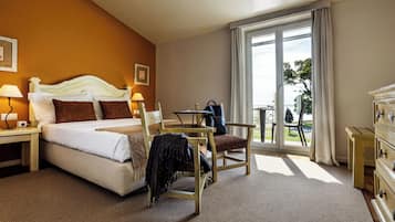 Una habitación de hotel con cama, escritorio, silla y vistas al exterior.