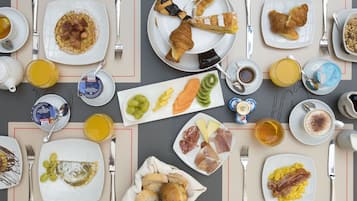 Un bufé de desayuno con diversas opciones de comida y bebidas.