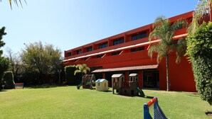A red building with a playground in front. - Hotel Misión Aguascalientes Zona Sur (Aguascalientes)
