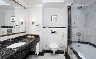 Ein modernes Badezimmer mit zwei Waschbecken, Toilette, Dusche und einem großen Spiegel.