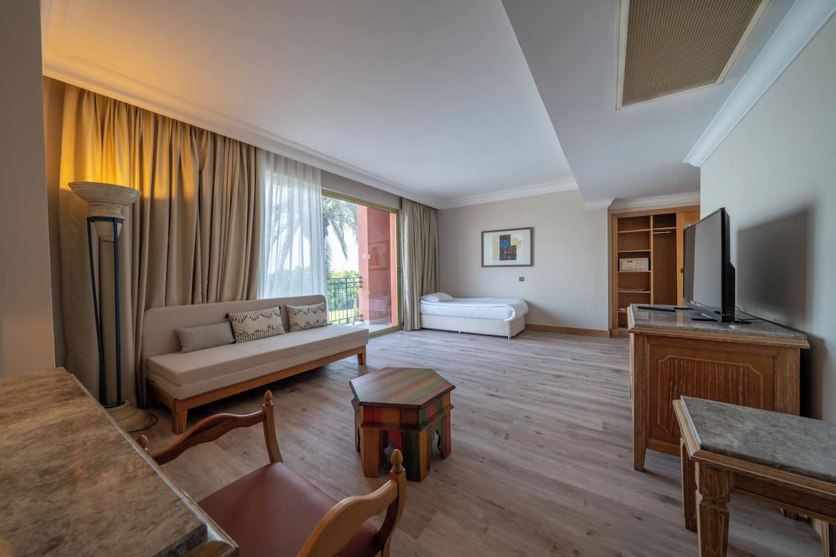 Un salón amplio con un sofá, una mesa de centro, un televisor y un armario de madera.