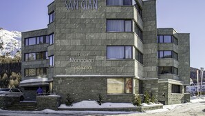 Um edifício de vários andares com fachada de pedra, identificado como Hotel San Gian e Restaurante Real Mongol.