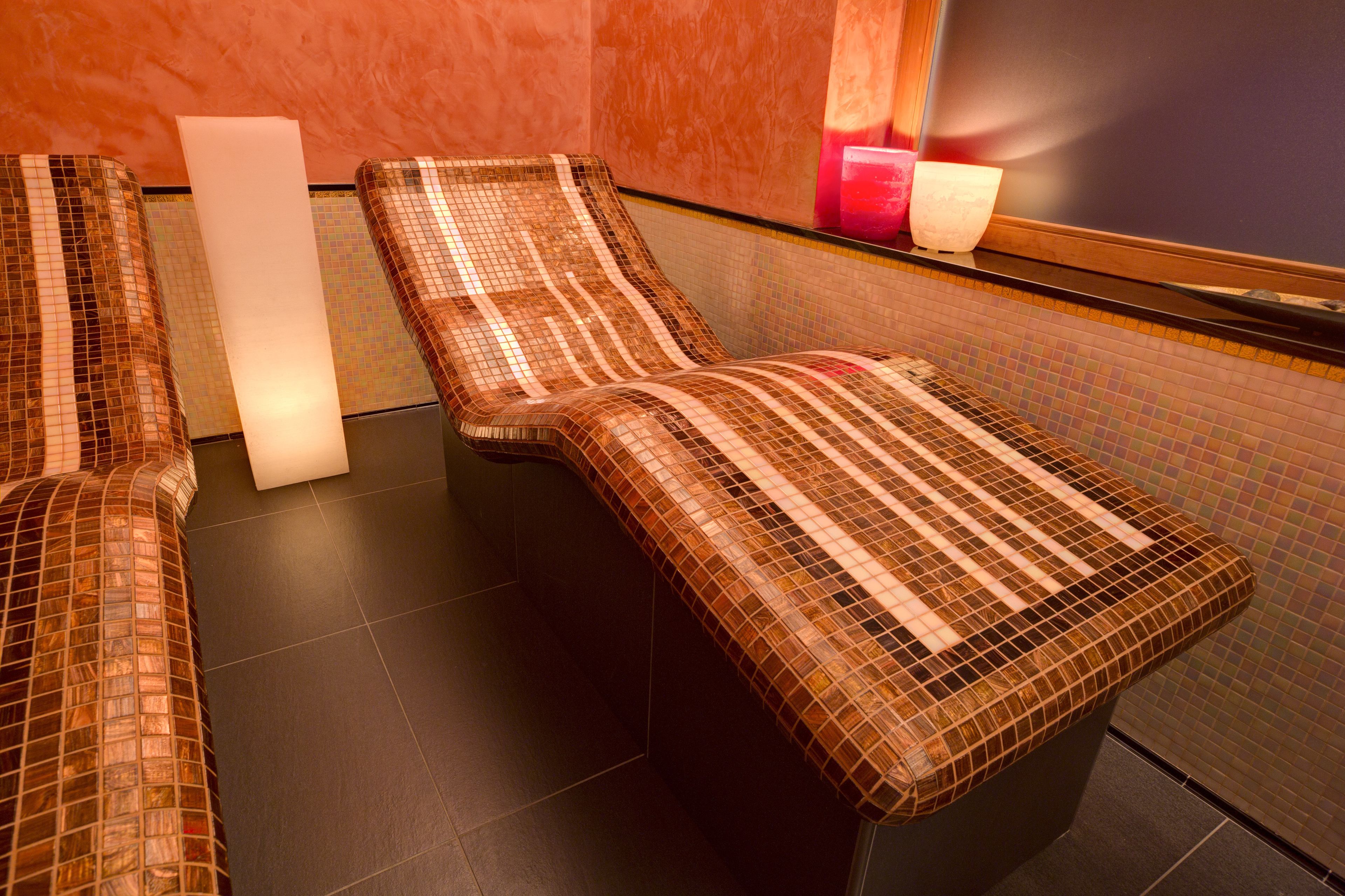A spa area with three reclining chairs and a large mirror.