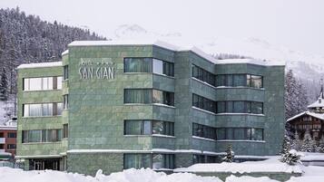 A hotel named 'San Gian' with a modern architectural style, featuring multiple windows and a snow-covered exterior.
