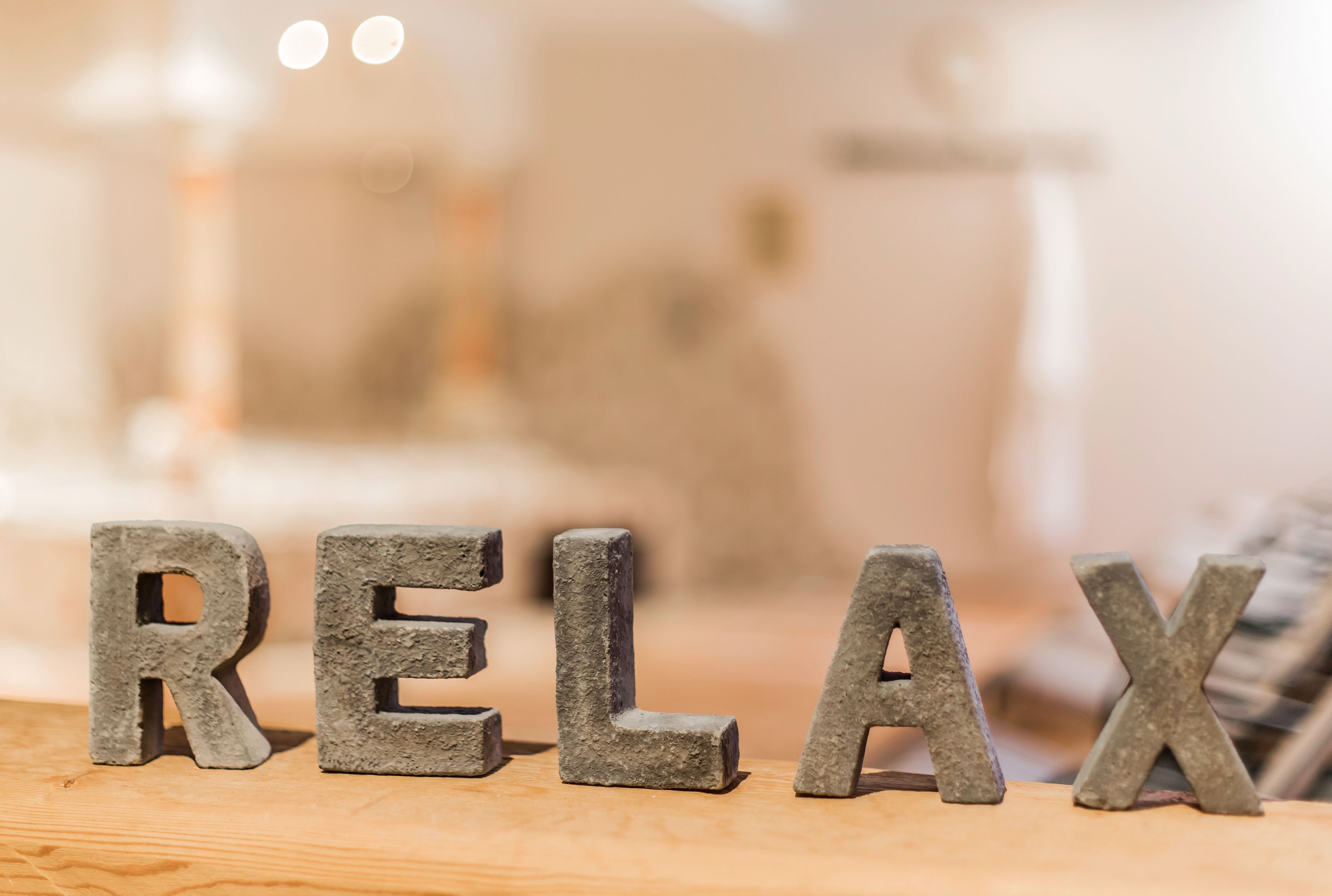 Wooden letters spelling "RELAX" on a table.