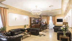 A luxurious living room with leather sofas, a chandelier, a bar area, and a large TV screen. - Hotel Villa Rosa (Rome)
