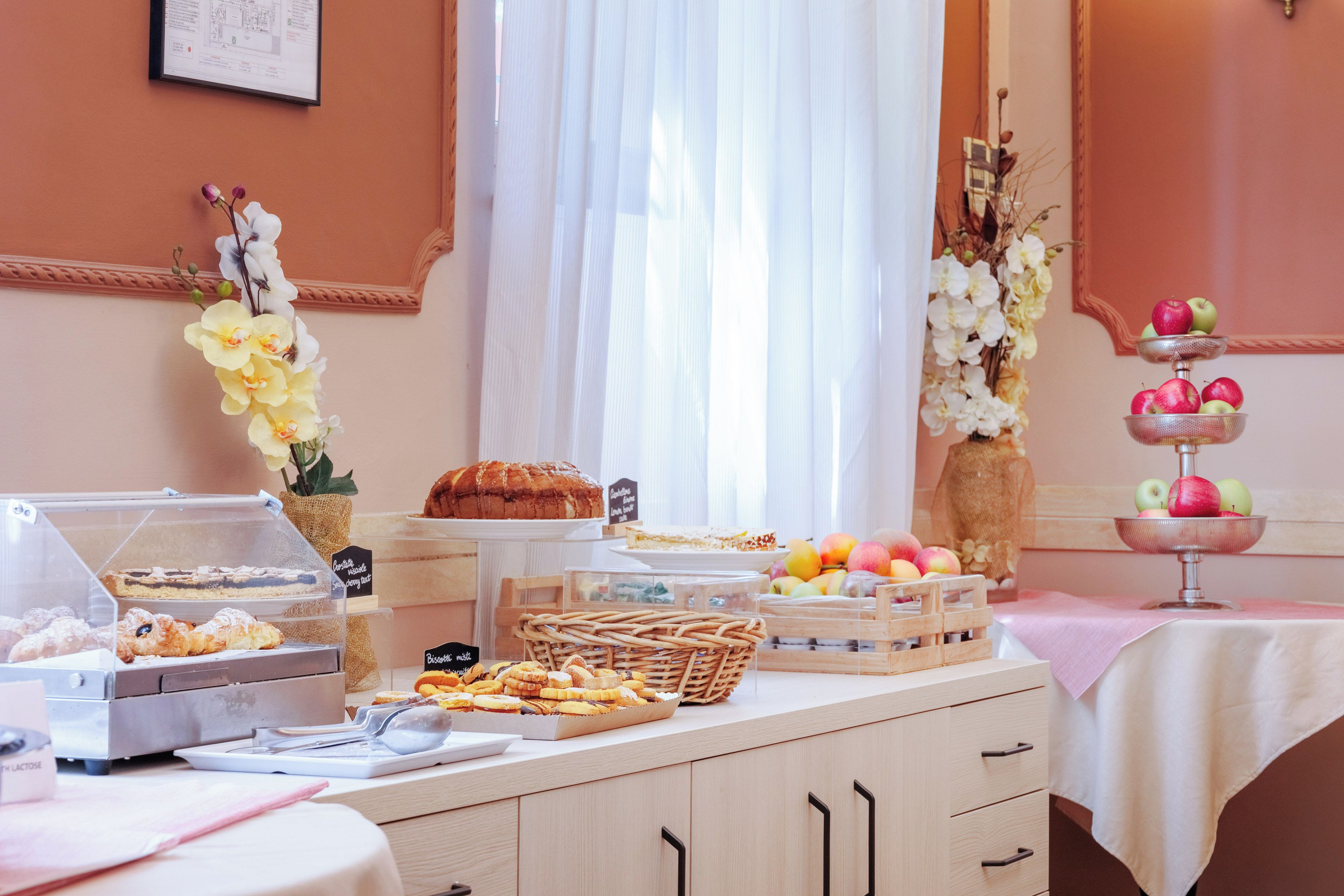 A buffet setup with various food items and a cake on display.