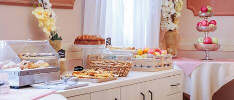 A buffet setup with various food items and a cake on display.