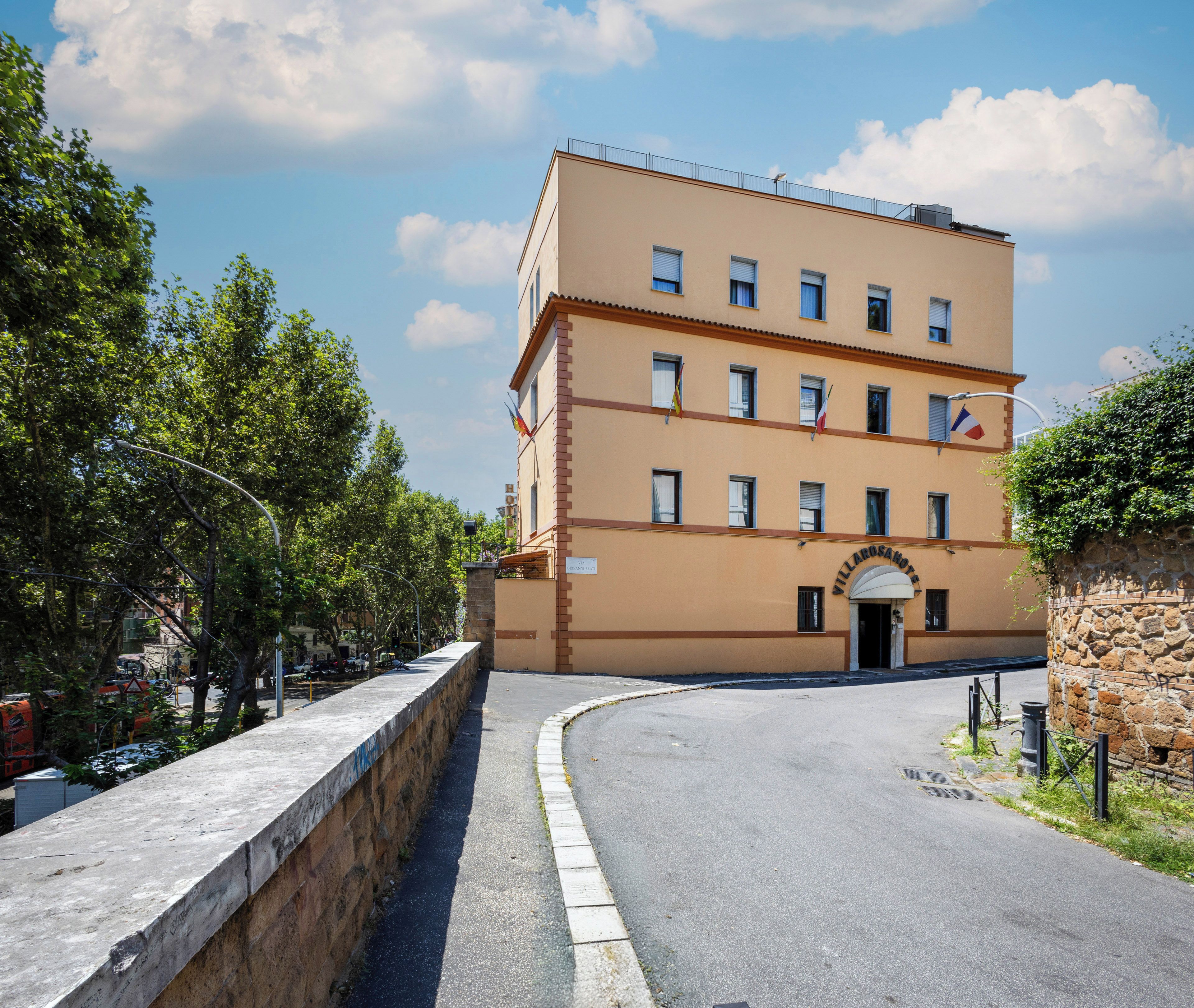 A multi-story hotel with a flat facade, a central entrance, and a clear sky.