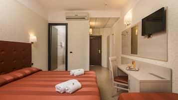 Une chambre d’hôtel avec deux lits, un bureau, une chaise, une télévision et un appareil de climatisation.