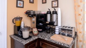 A kitchenette with a coffee machine, toaster, and a coffee station. - Americas Best Value Inn & Suites Waller Prairie View (Waller)