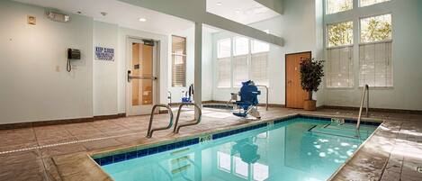 A swimming pool with a lift chair, a phone, and a sign indicating the pool is closed.