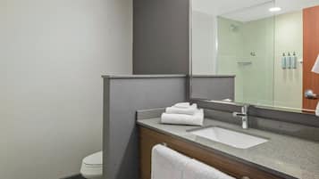 Baño con lavamanos, espejo y ducha.