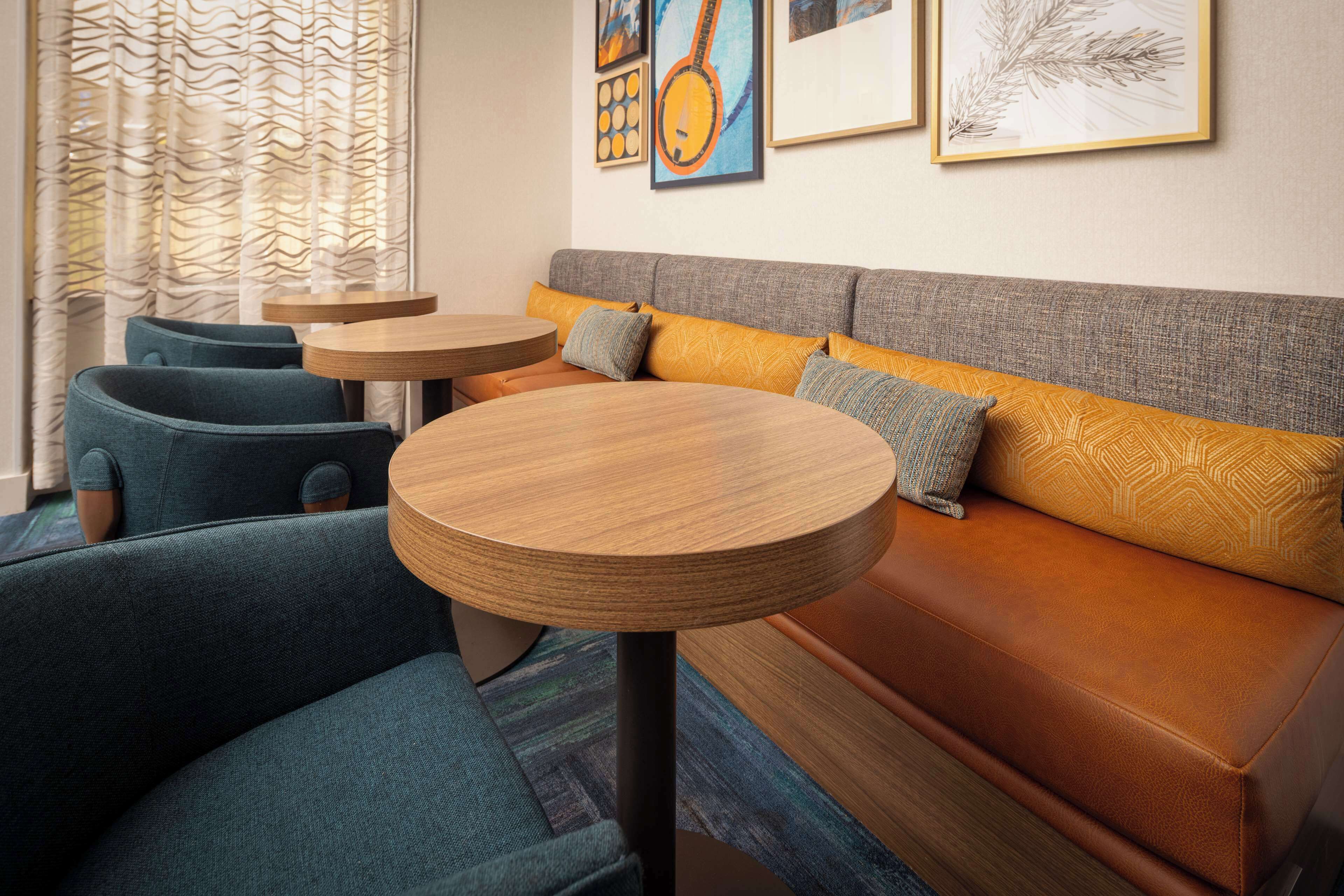 Ein modernes Interieur mit einer Couch, zwei runden Tischen und einem gemusterten Vorhang.