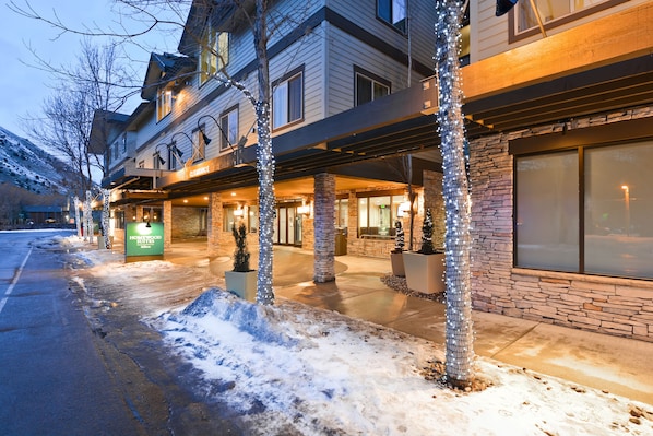 A hotel with a covered outdoor area, a sign for "Homewood Suites," and a stone facade.
