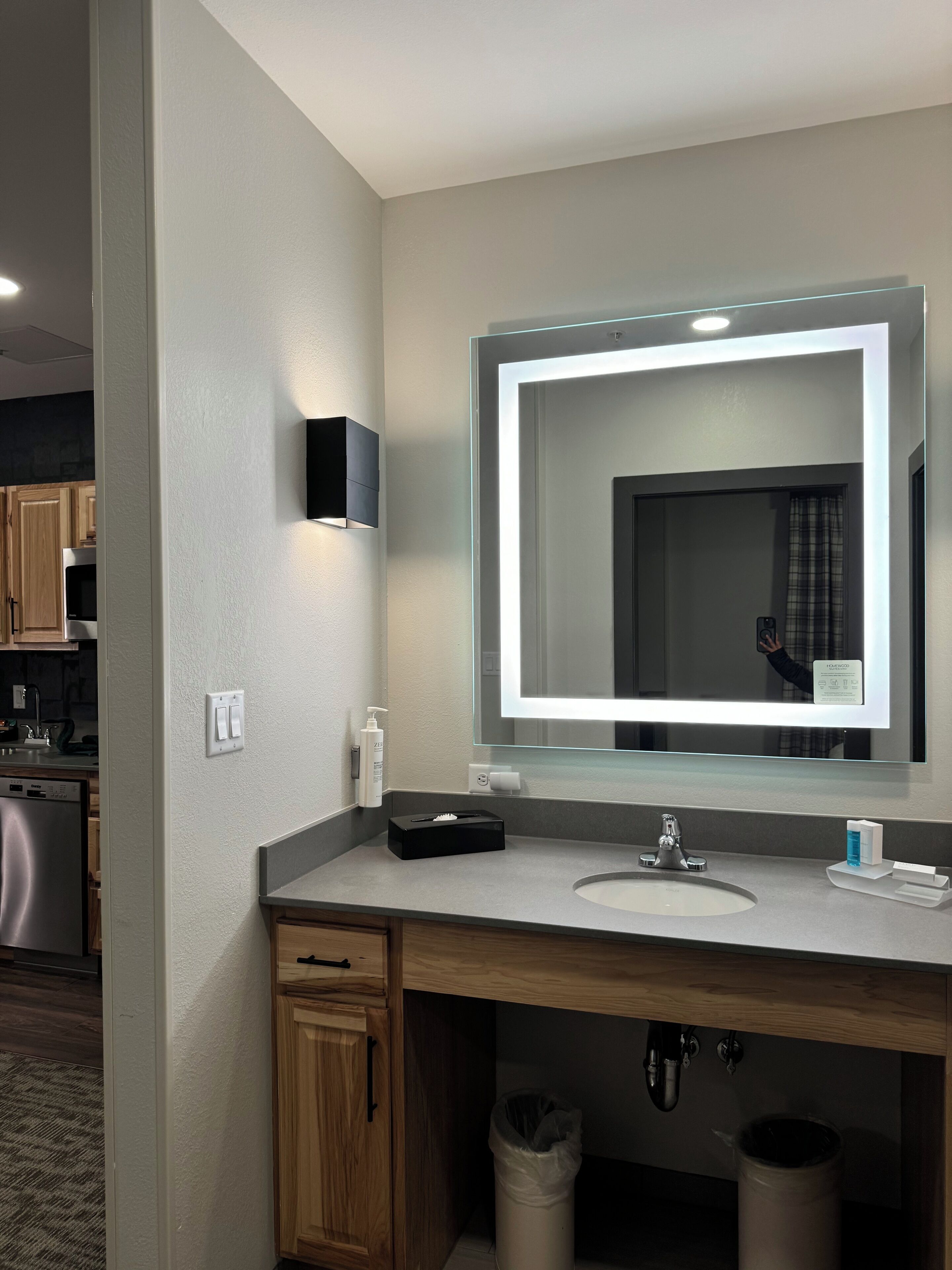 A modern bathroom with a large mirror, a sink, and a vanity.