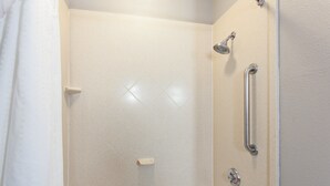 A bathroom with a shower, grab bars, and a bathtub. - Holiday Inn Express Hotel & Suites Wharton by IHG (Wharton)
