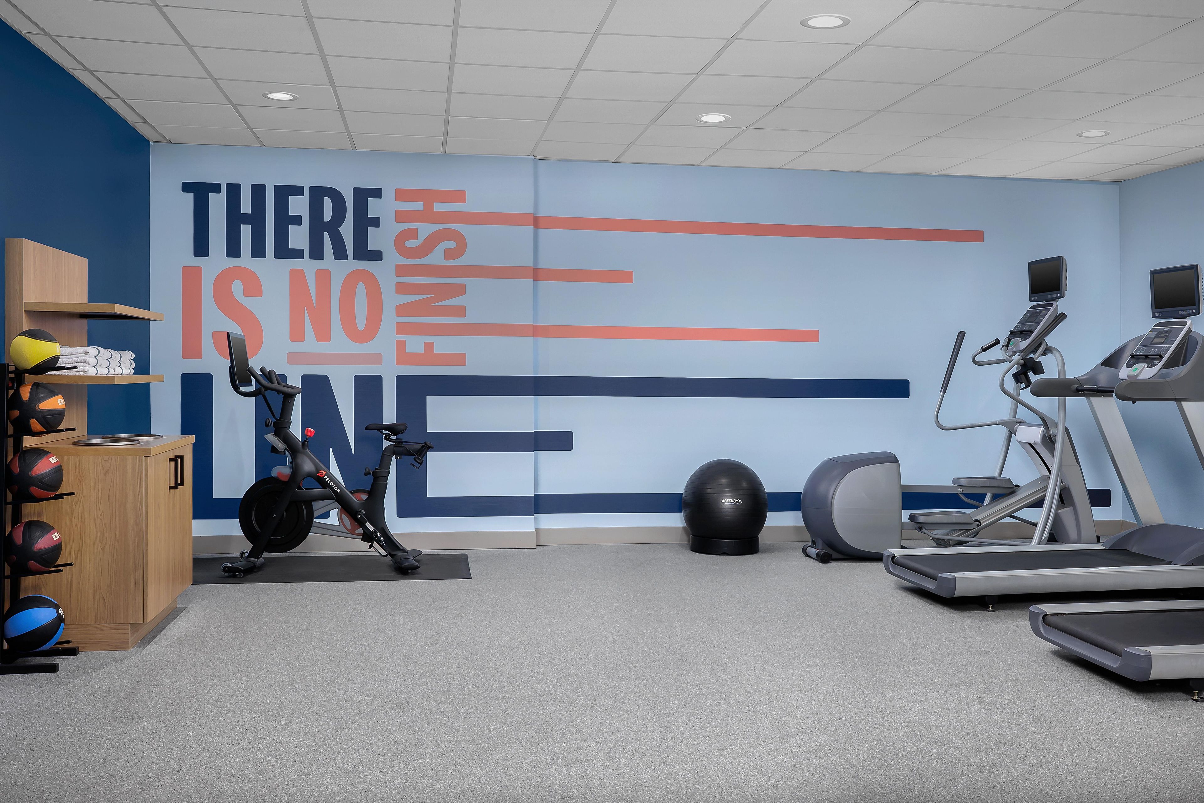 A gym with exercise equipment including a stationary bike, elliptical, and treadmill.
