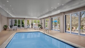 A pool area with a clear view of the outdoors, including a patio with chairs and umbrellas. - Hampton Inn & Suites Clinton - I-26 (Clinton)