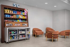 A snack and beverage kiosk with a variety of snacks and drinks, including chips and bottled beverages. - Hampton Inn & Suites Clinton - I-26 (Clinton)