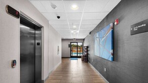 Un pasillo con un ascensor, un letrero que dice 'Ice & Vending Pool' y vistas al área de la piscina.
