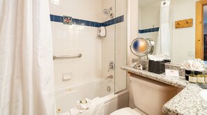 Een bad/douchecombinatie, een bubbelbad, een haardroger, handdoeken