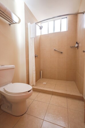 A bathroom with a toilet, a shower with a grab bar, and a window. - Gamma Durango Plaza Vizcaya (Durango)